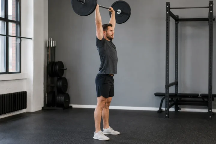 Trening push pull: wyciskanie sztangi nad głowę stojąc w dniu push
